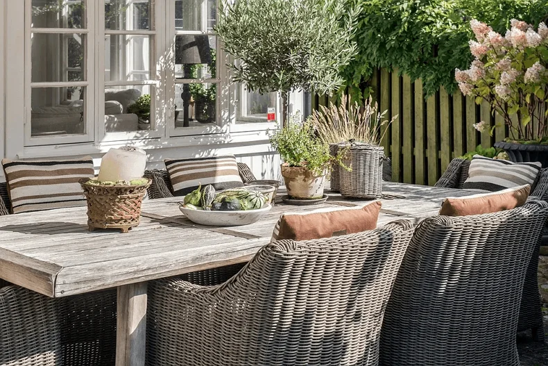 Un espace repas extérieur avec une grande table et des chaises confortables